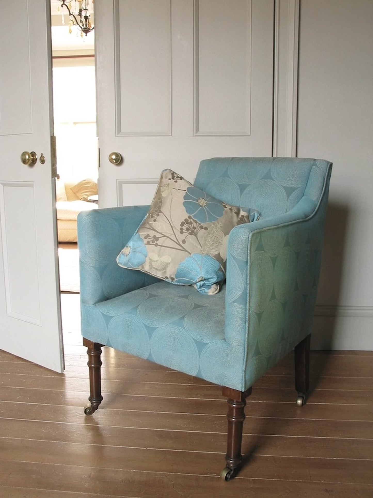 ADAM fabric by Arte Fresca Outlet, featuring its geometric concentric circle pattern, upholstered on an armchair in a rich, solid color (e.g., deep blue, forest green, warm grey), showcasing the fabric's tactile relief texture and elegant drape for furniture.