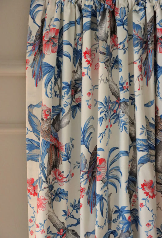 Allegria Blue/Cream fabric by Arte Fresca Outlet elegantly folded, demonstrating its beautiful drape and suitability as a curtain fabric, revealing the vibrant tropical pattern on a cream background.