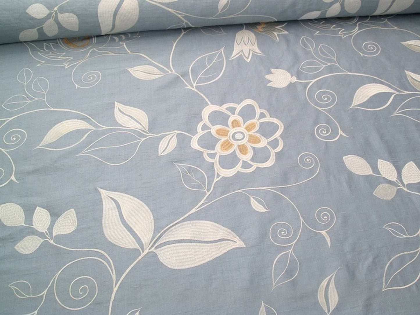 MOREEN AQUA embroidered silk fabric by Arte Fresca Outlet, a luxurious blend of 80% silk and 20% rayon. It features a large-scale, tactile floral embroidery in silvery ivory and creamy beige on a soft, subtly shimmering aqua light-blue ground, perfect for elegant romantic interiors.