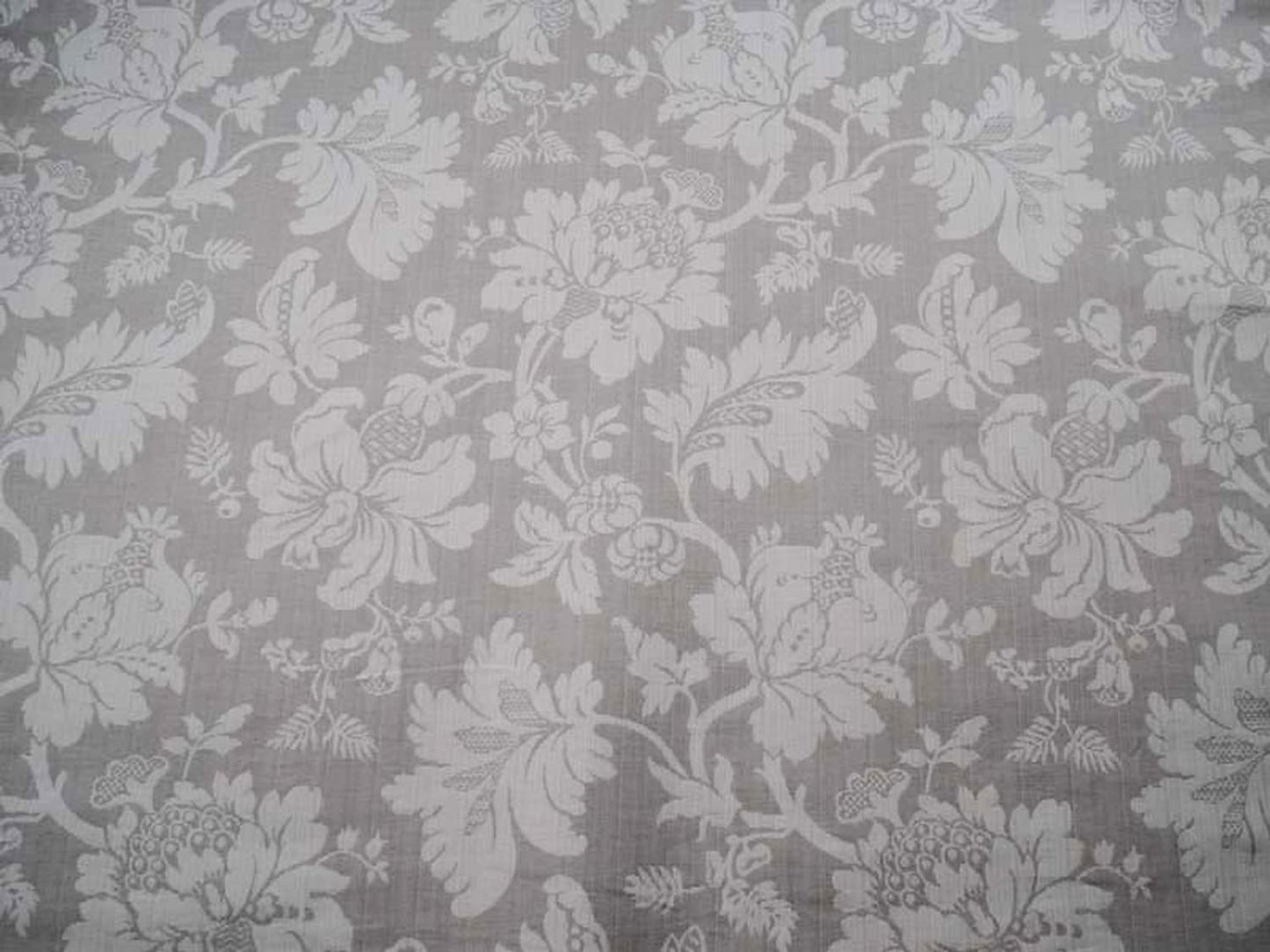 Close-up of MARY GREY fabric by Arte Fresca Outlet, showcasing its detailed floral jacquard pattern in beige on a cool grey background, ideal for curtains or upholstery.