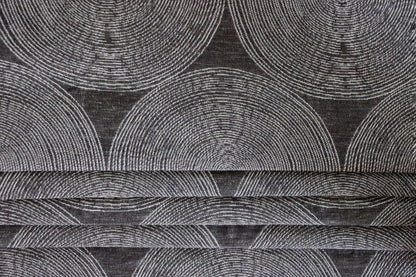 ADAM CHARCOAL fabric by Arte Fresca Outlet, folded precisely like a Roman blind, highlighting its structured yet adaptable nature, the elegant concentric circle pattern, and its ability to create clean, sophisticated window coverings.