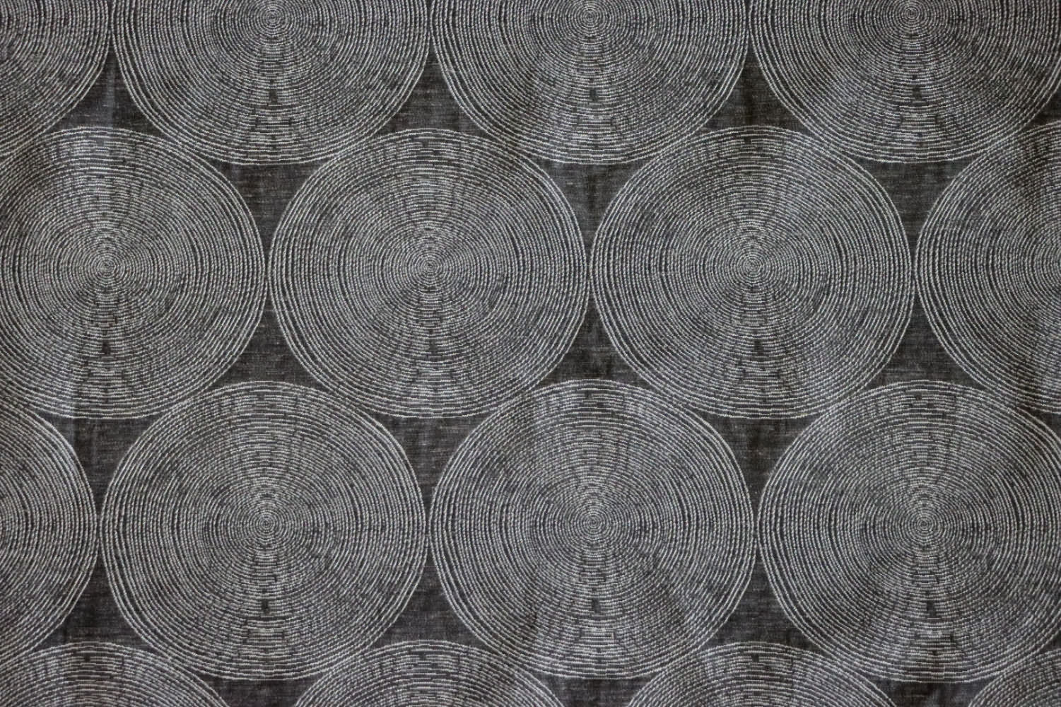  ADAM CHARCOAL fabric by Arte Fresca Outlet, a full view displaying its elegant deep anthracite base and subtle concentric circle pattern in cream and silver-grey, showcasing its woven texture and modern aesthetic.