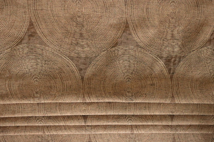 Voisin Gold fabric by Arte Fresca Outlet folded like a Roman blind, illustrating its structured appearance and warm copper and cream concentric circle pattern, perfect for window treatments.
