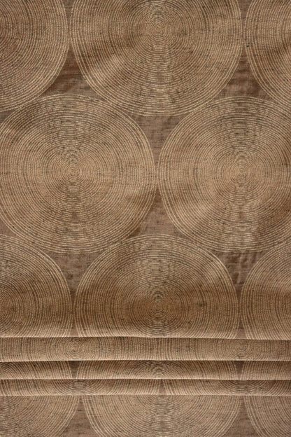 Voisin Gold fabric by Arte Fresca Outlet folded like a Roman blind, illustrating its structured appearance and warm copper and cream concentric circle pattern, perfect for window treatments.
