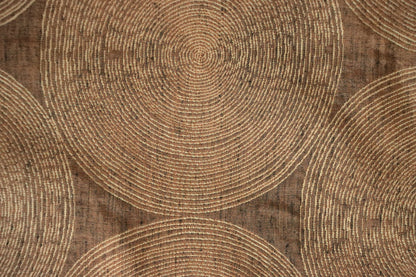 Close-up of Voisin Gold fabric by Arte Fresca Outlet, highlighting its fine weave, subtle cream concentric circles, and warm copper tones, revealing the tactile appeal and quality.