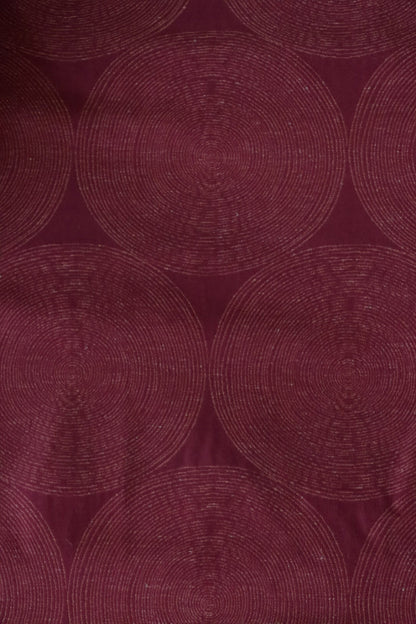 Close-up of ADAM RED fabric from Arte Fresca Outlet, revealing the intricate woven details of its overlapping concentric circle pattern, the relief texture, and the rich, shimmering burgundy to brick red tones with slight variations.