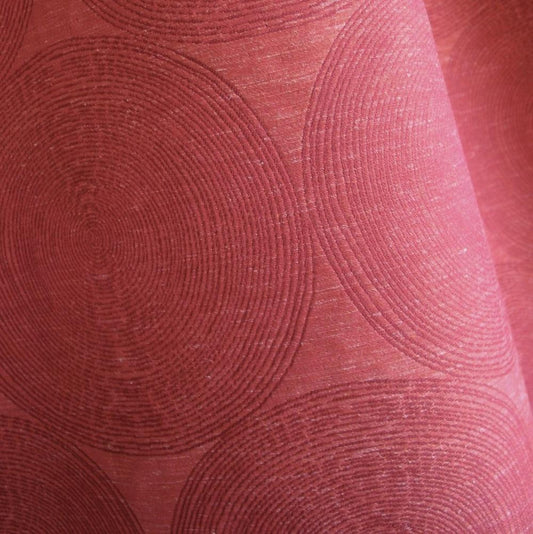 Close-up of ADAM RED fabric from Arte Fresca Outlet, revealing the intricate woven details of its overlapping concentric circle pattern, the relief texture, and the rich, shimmering burgundy to brick red tones with slight variations.