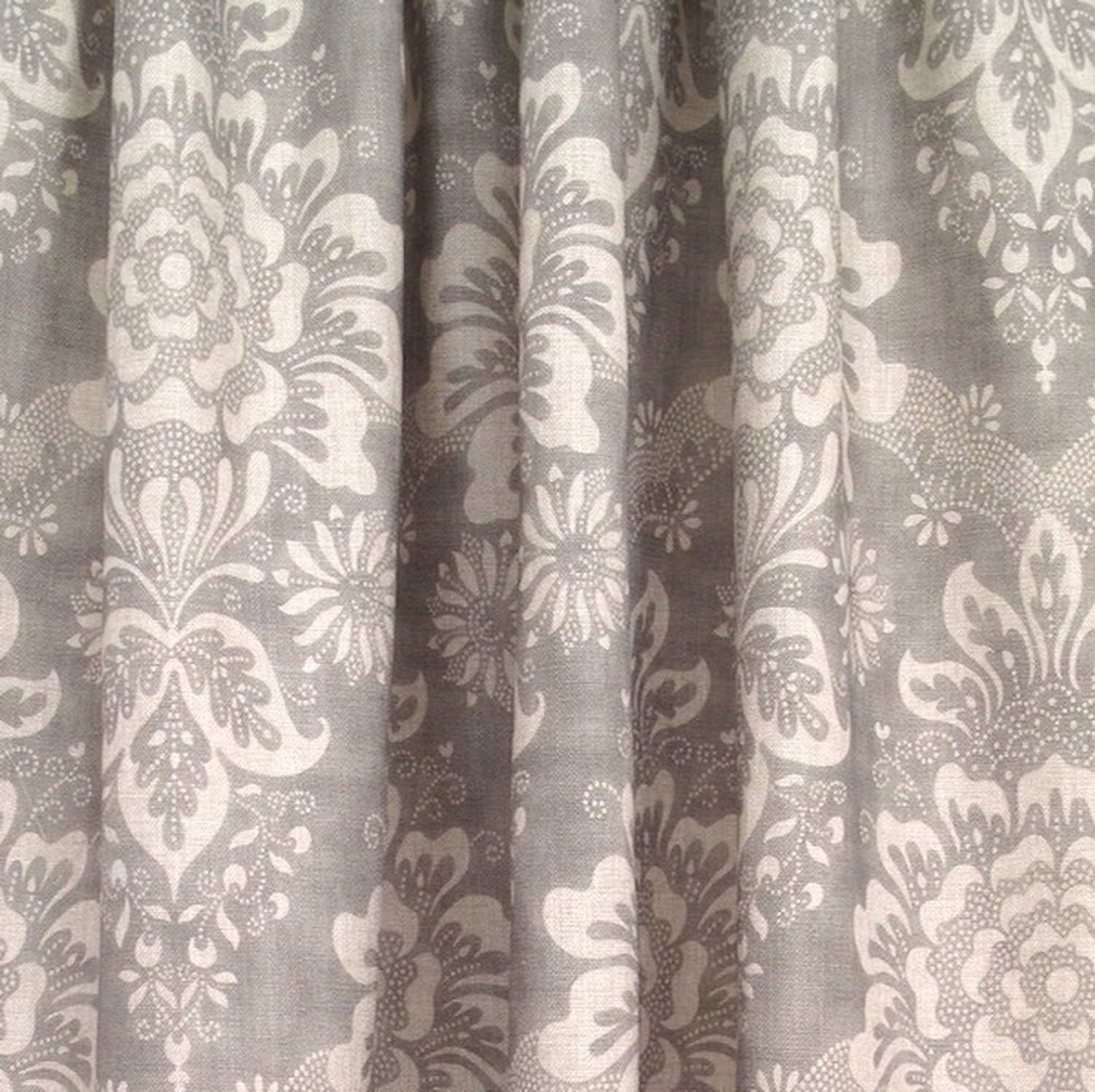 Adele Grey fabric by Arte Fresca Outlet elegantly folded, demonstrating its beautiful drape and suitability as a curtain fabric, revealing the classic floral pattern in soft grey and ivory.
