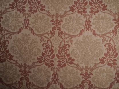 Damask patterned in warm beige and muted terracotta red.