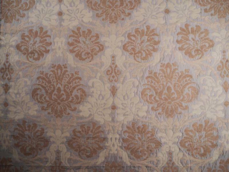 Damask patterned fabric with a warm brown floral motif on a light beige background.