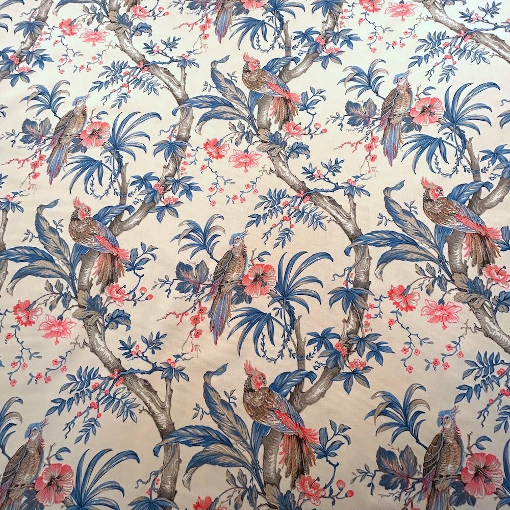 ALLEGRIA BLUE/CREAM fabric coupon by Arte Fresca Outlet, a reduced French 100% cotton remnant. It features a detailed tropical design with a vibrant parrot amidst lush hibiscus blossoms and gentle foliage in soft blue, red, and warm beige tones on a cream background, perfect for small sewing projects.