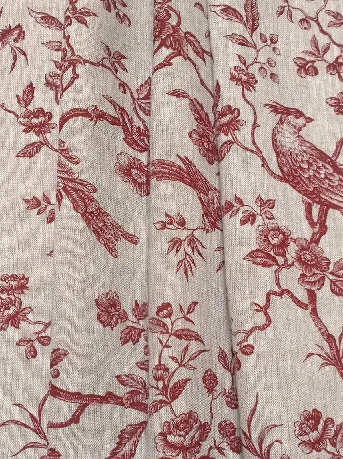 The Conway Lin Red fabric coupon styled in gentle folds, demonstrating its suitability for curtains and decoration with a charming, timeless feel.