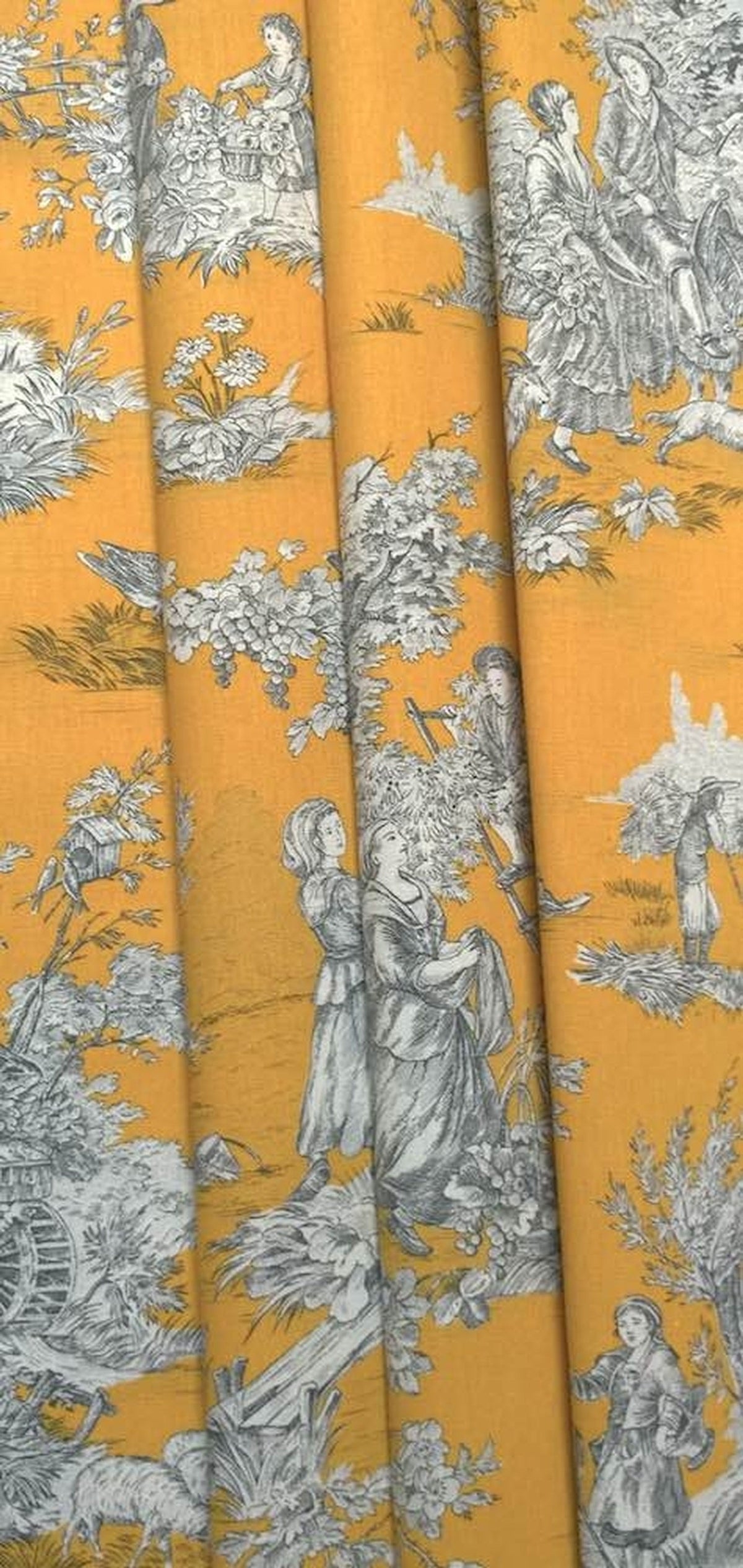 The Toile de Jouy Moutarde fabric coupon styled in gentle folds, demonstrating its suitability for curtains and decoration with a charming, timeless feel.