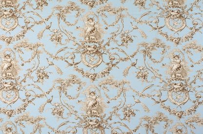 A close-up of a repeating toile-style pattern with beige cherub and floral scroll motifs on a light blue background.