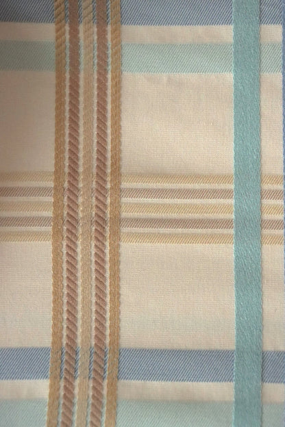 Close-up of BRAXTON CHECK BLUE/CREAM fabric from Arte Fresca Outlet, revealing the intricate weave of its blue, cream, and brown check pattern, showcasing the soft cotton-viscose blend and subtle color variations.