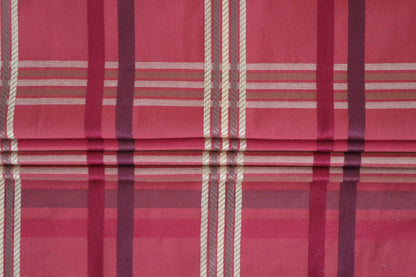 BRAXTON CHECK RASPBERRY fabric from ARTE FRESCA Outlet arranged to show its suitability for Roman blinds. The structured folds highlight the crispness of the check pattern, perfect for adding a touch of British elegance to windows.