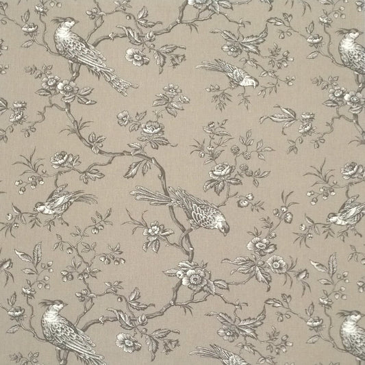 A large view of the Conway Brown French cotton fabric from Arte Fresca Outlet, featuring a romantic, grey bird and branch pattern on a warm beige background.