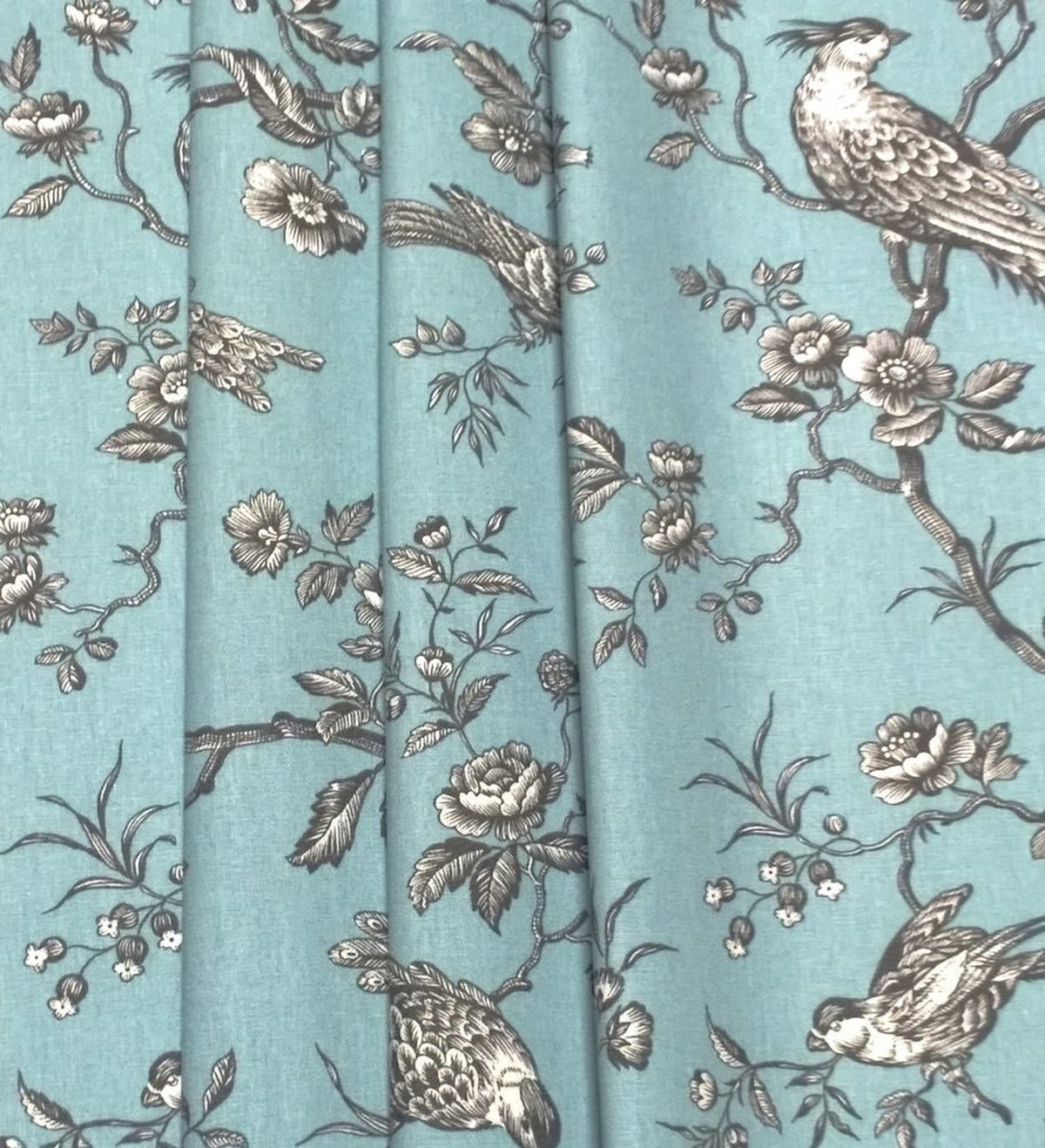 Conway Ciel fabric shown in elegant folds, illustrating its use as a curtain material. The romantic bird motif from Arte Fresca Outlet is beautifully displayed in the drapery.