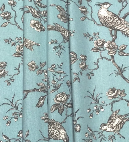 Conway Ciel fabric shown in elegant folds, illustrating its use as a curtain material. The romantic bird motif from Arte Fresca Outlet is beautifully displayed in the drapery.