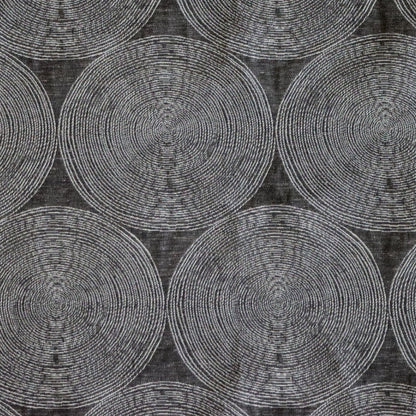 Close-up of ADAM CHARCOAL fabric from Arte Fresca Outlet, revealing the fine weave, the subtle texture within its concentric cream and silver-grey circles on deep anthracite, emphasizing its quality and sophisticated detail.