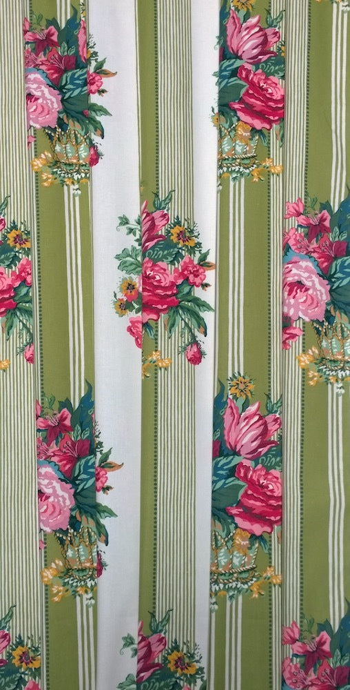 A close-up of a striped fabric with vertical olive green and white stripes, decorated with pink and red floral bouquets and small yellow flowers.
