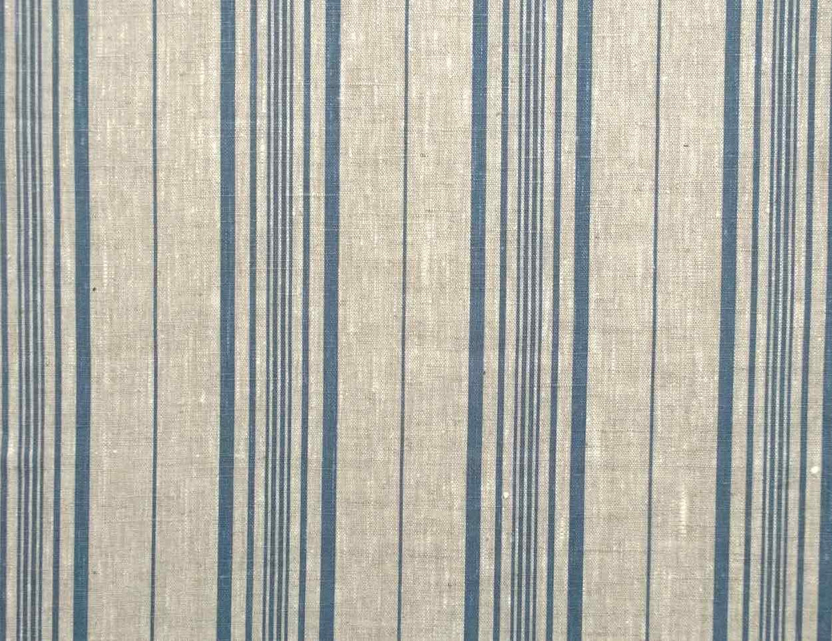 A close-up of a woven fabric with a textured beige background and vertical stripes in navy blue and thin gray lines.