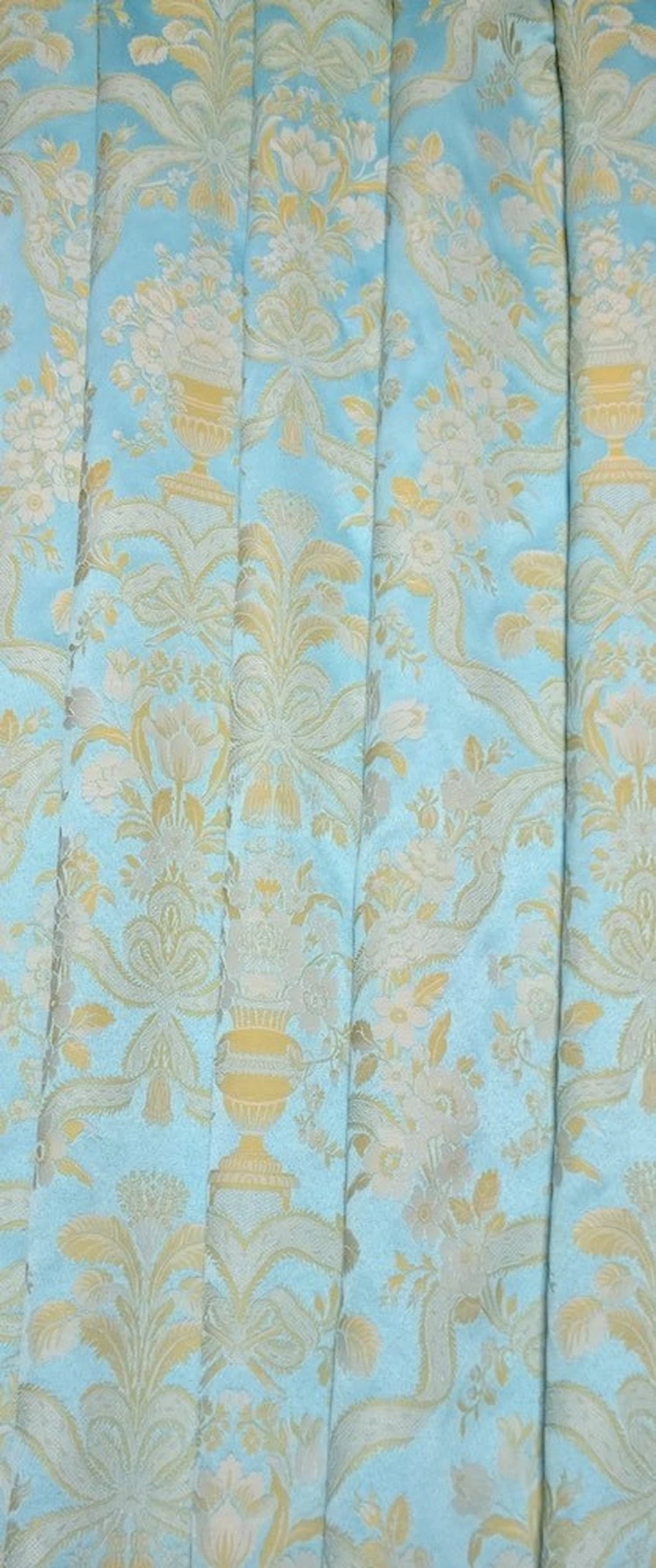 Lorraine Turquoise woven fabric shown in elegant folds, illustrating its use as a curtain material. The light-catching quality of the fabric from Arte Fresca Outlet is beautifully displayed.