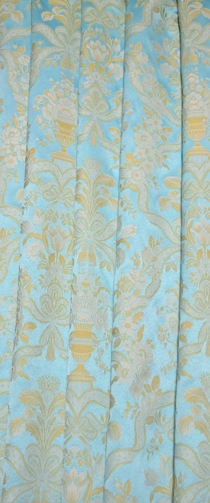 Lorraine Turquoise woven fabric shown in elegant folds, illustrating its use as a curtain material. The light-catching quality of the fabric from Arte Fresca Outlet is beautifully displayed.
