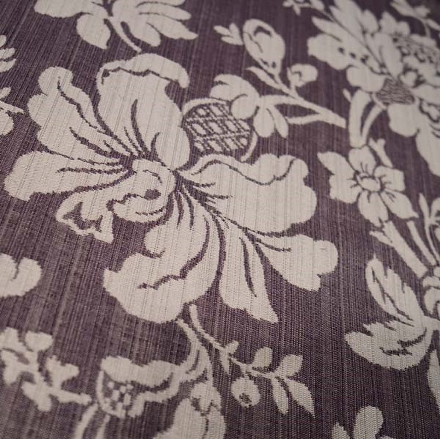 Close-up of MARY AUBERGINE jacquard fabric from Arte Fresca Outlet, revealing the intricate details of its large floral pattern, the rich aubergine and beige tones, and the tactile, raised texture characteristic of jacquard weaving.