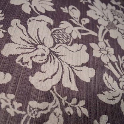 Close-up of MARY AUBERGINE jacquard fabric from Arte Fresca Outlet, revealing the intricate details of its large floral pattern, the rich aubergine and beige tones, and the tactile, raised texture characteristic of jacquard weaving.