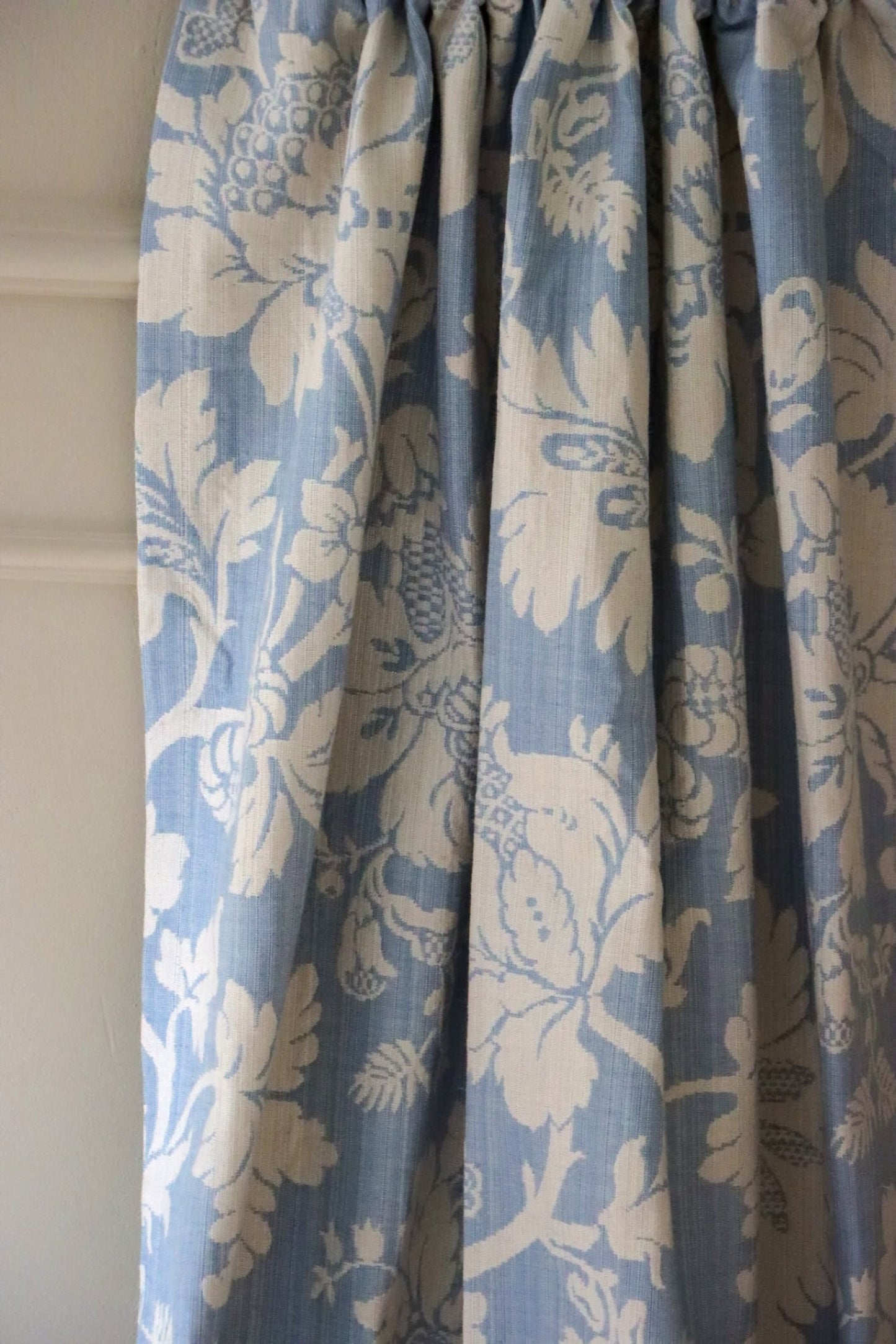 Mary Light Blue jacquard fabric by Arte Fresca Outlet elegantly folded like a curtain, demonstrating its beautiful drape and suitability for sophisticated window treatments.