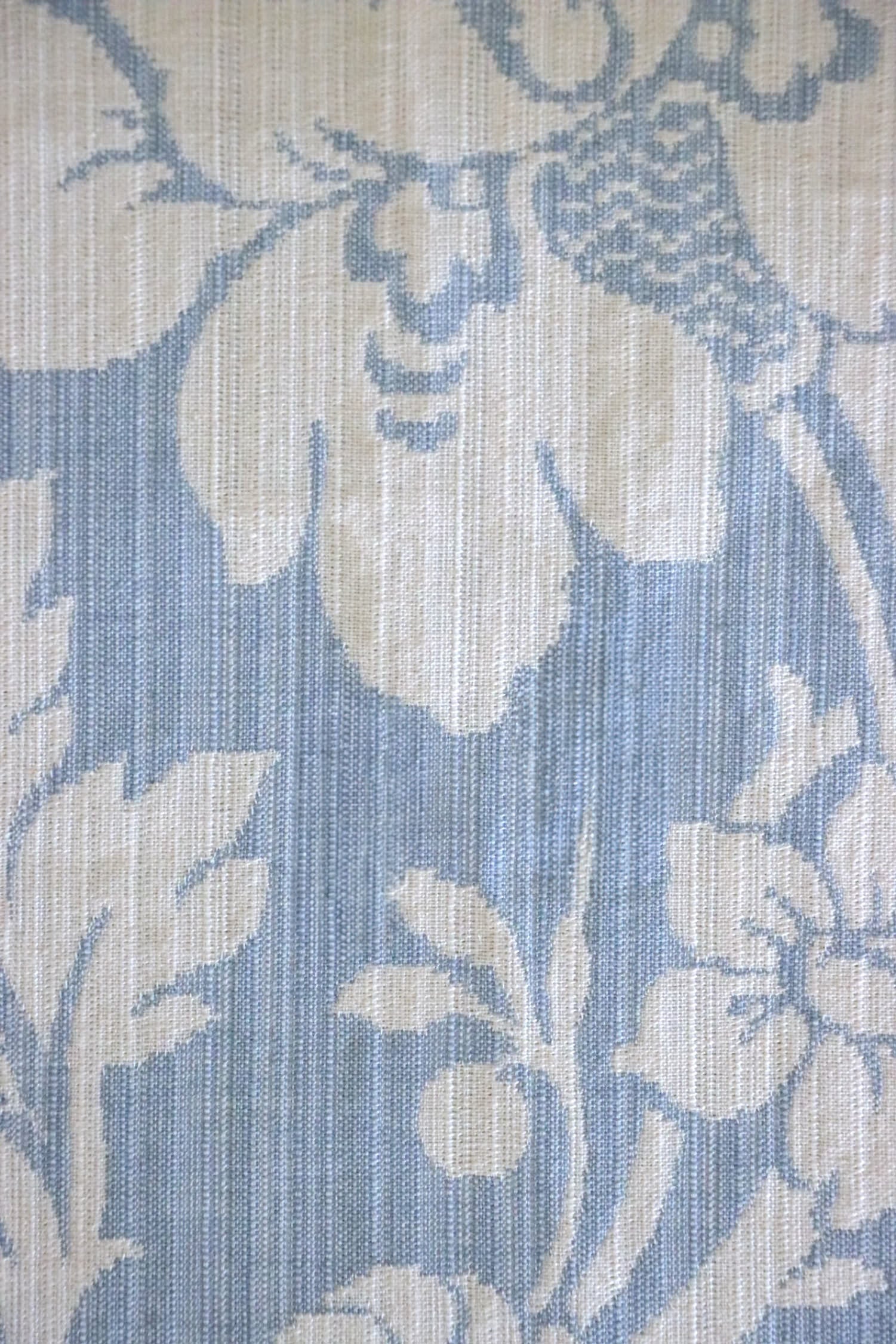 Close-up of Mary Light Blue jacquard fabric by Arte Fresca Outlet, highlighting the intricate white floral motif and luxurious texture on a soft powder blue background.