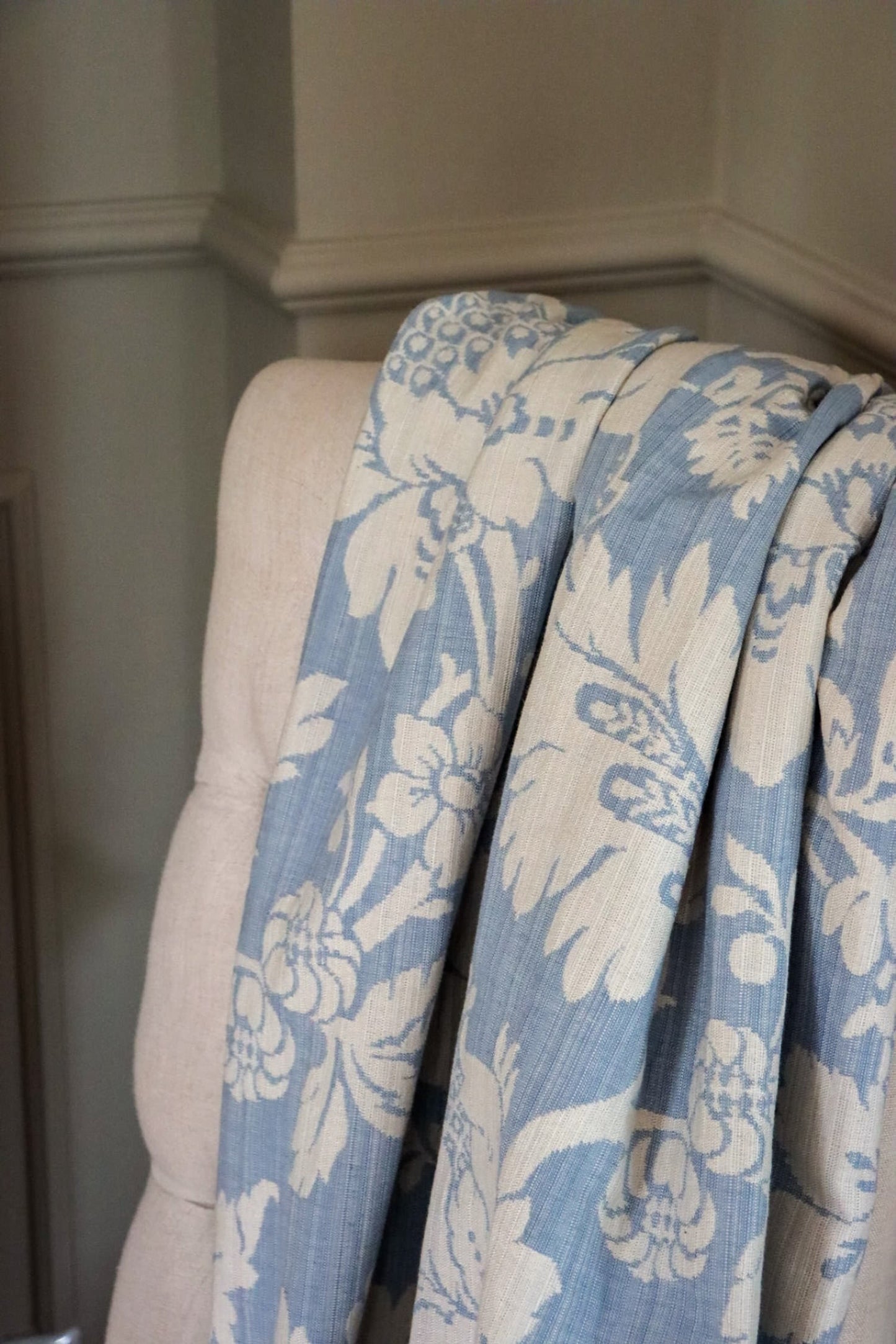 Mary Light Blue jacquard fabric from Arte Fresca Outlet loosely draped over a light upholstered chair back, showcasing the pattern size and elegant flow for home interiors.