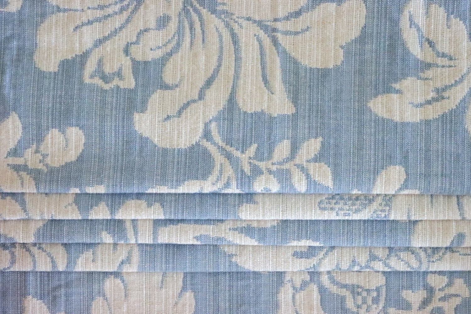 Mary Light Blue jacquard fabric from Arte Fresca Outlet folded to resemble a Roman blind, illustrating its structured yet elegant appearance for modern window coverings.