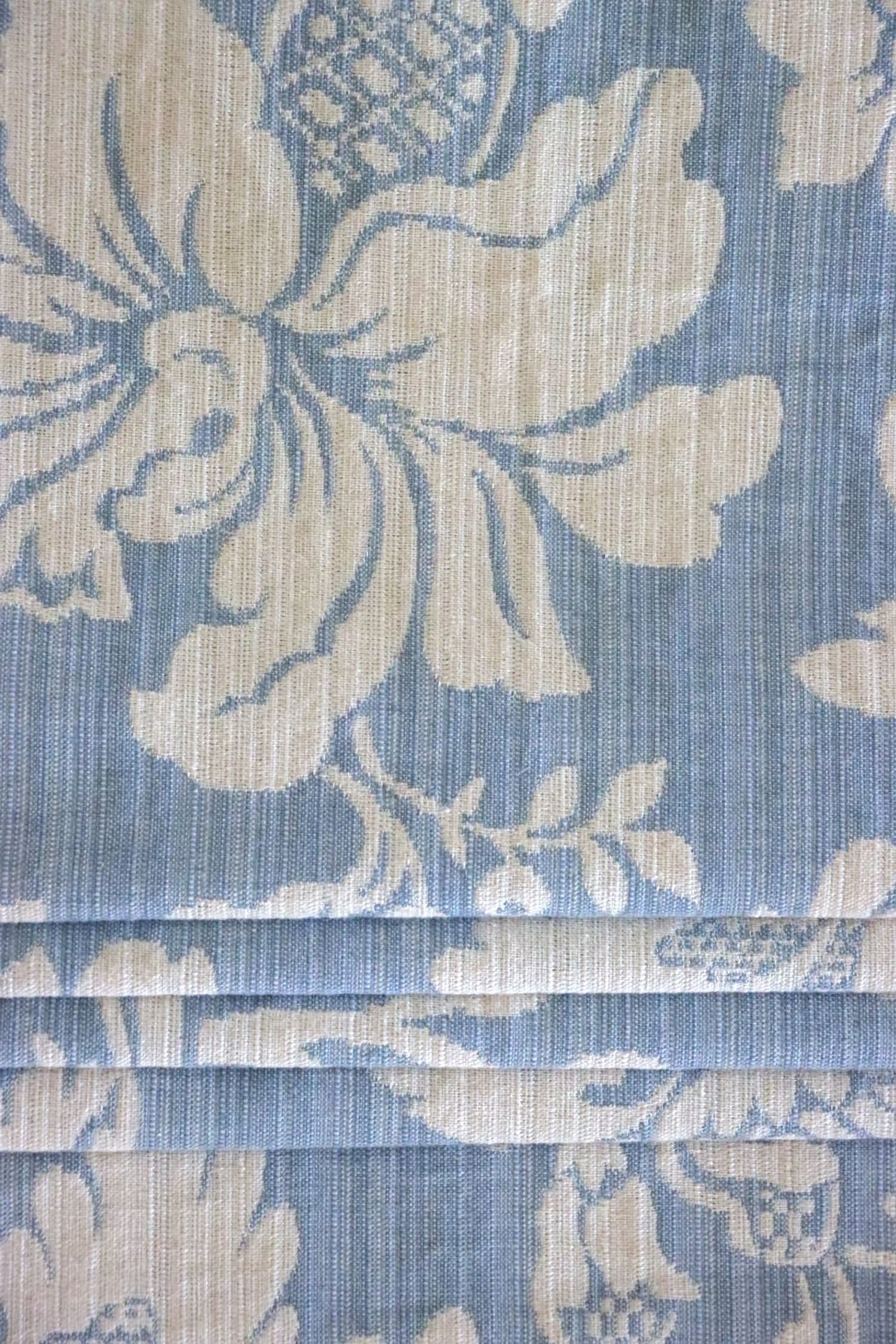 Mary Light Blue jacquard fabric from Arte Fresca Outlet folded to resemble a Roman blind, illustrating its structured yet elegant appearance for modern window coverings.
