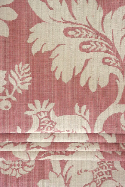  MARY ROSE jacquard fabric from Arte Fresca Outlet folded compactly like a window blind, emphasizing its refined woven texture and the prominent creamy white floral pattern on old rose. This versatile jacquard is suitable for elegant roller blinds and decorative projects, offering a touch of classic, romantic beauty.