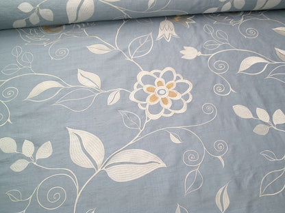 MOREEN AQUA embroidered silk fabric by Arte Fresca Outlet, a luxurious blend of 80% silk and 20% rayon. It features a large-scale, tactile floral embroidery in silvery ivory and creamy beige on a soft, subtly shimmering aqua light-blue ground, perfect for elegant romantic interiors.