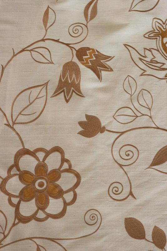 Close-up of MOREEN CAMEL silk fabric from Arte Fresca Outlet, revealing the intricate details of its fine embroidered floral motifs in brown, the soft camel base, and the tactile, raised quality of the exquisite silk and embroidery.