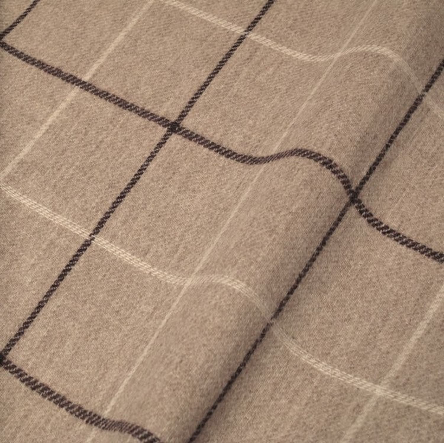 Close-up of OXFORD CHECK PLUM fabric from Arte Fresca Outlet, showcasing the finely woven 100% wool texture and the classic check pattern with subtle plum and cream white lines on a warm light beige background, emphasizing its soft feel.