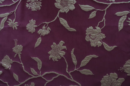  PENCARROW DARK RED silk fabric by Arte Fresca Outlet, showcasing its deep dark red color with a subtle gold shimmer and an ornate floral design of stylized peonies or camellias in light gold-silver tones on a smooth, luxurious textured surface.