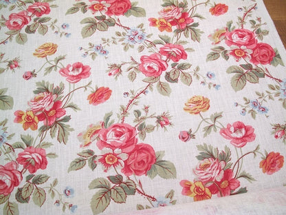 PHILIPPA PINK floral fabric by Arte Fresca Outlet, a full view displaying its romantic English country garden pattern with opulent roses in crimson and raspberry pink, delicate blue and golden yellow wildflowers, and green foliage on a woven off-white linen blend.