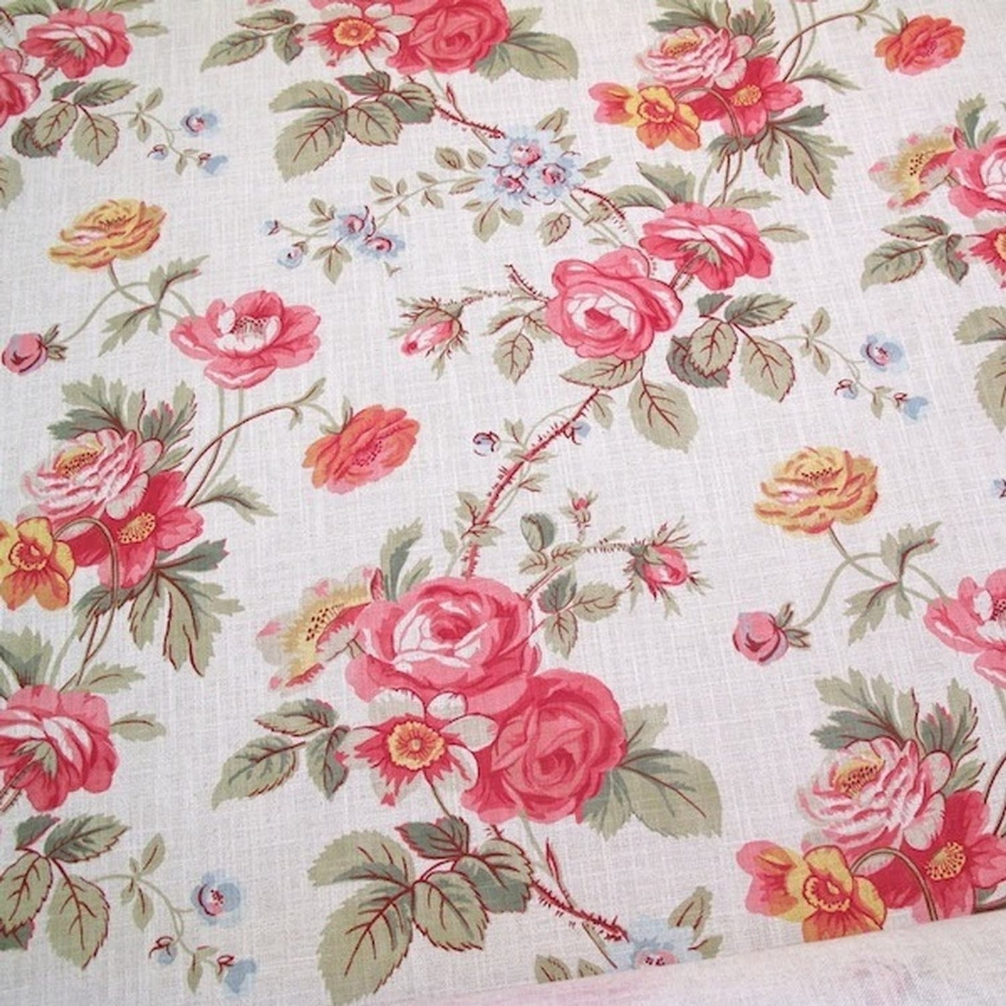 PHILIPPA PINK floral fabric by Arte Fresca Outlet, a full view displaying its romantic English country garden pattern with opulent roses in crimson and raspberry pink, delicate blue and golden yellow wildflowers, and green foliage on a woven off-white linen blend.