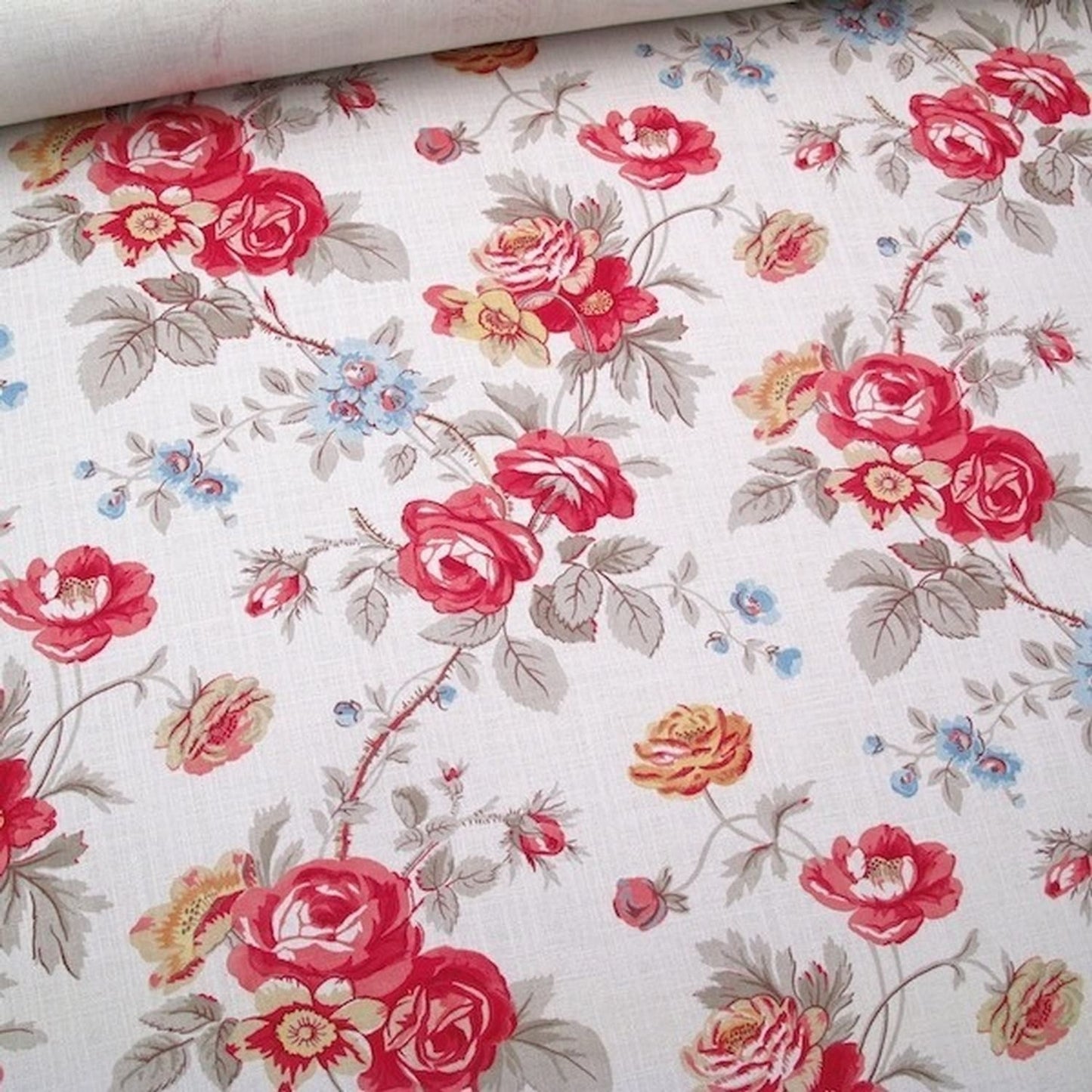 Close-up of Philippa Red fabric by Arte Fresca Outlet, detailing the opulent red roses, delicate blue and yellow wildflowers, and subtle cream texture of the printed linen blend.