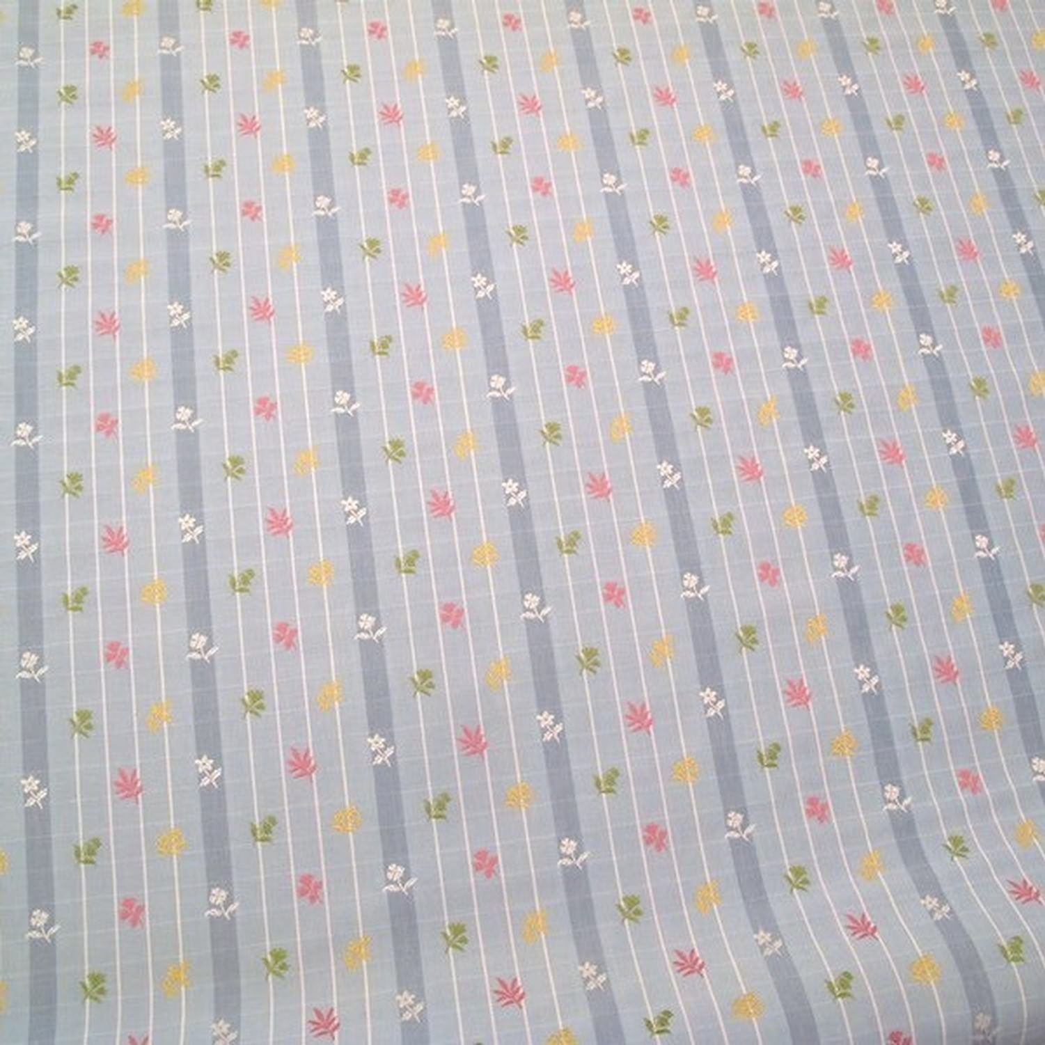 SHIRLEY BLUE fabric by Arte Fresca Outlet, a full view displaying its vertical blue stripes with white grid pattern and embroidered floral motifs in pink, yellow, and green, highlighting its charming English country style.