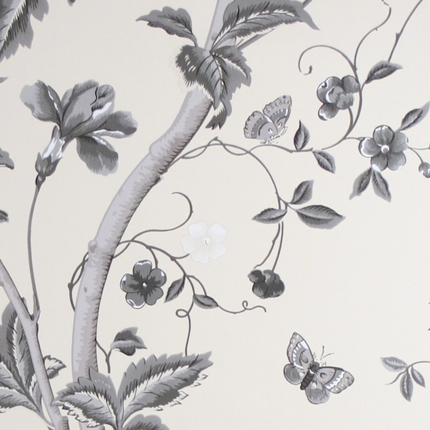 Close-up of SUMMER PALACE CHARCOAL wallpaper by Laura Ashley at Arte Fresca Outlet. The smooth paper surface reveals intricate plant tendrils, large blossoms, leaves, butterflies, and a delicate bird in varying shades of grey, anthracite, black, and white on a cream background, showcasing the pattern's drawing precision and depth.