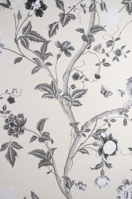 SUMMER PALACE CHARCOAL wallpaper by Laura Ashley at Arte Fresca Outlet. This exquisite paper wallcovering features a detailed floral and botanical pattern with graceful plant tendrils, large blossoms, leaves, butterflies, and a delicate bird, all rendered in an elegant black-white-grey scale on a warm, cream-colored background, embodying classic elegance and romantic Asian poetry.