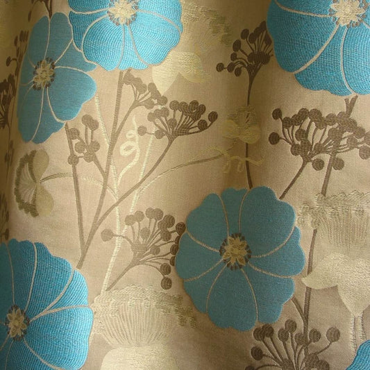 Close-up of VALENTIN TURQUOISE jacquard woven fabric from Arte Fresca Outlet, revealing the raised, textured turquoise-blue blossoms and intricate details of the floral pattern against the subtly shimmering beige background, showcasing the rich weave and blend of viscose, cotton, linen, and polyamide for upholstery and decor.