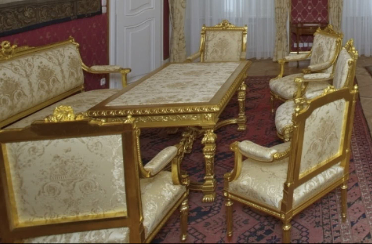 A collection of antique-style chairs and armchairs upholstered with the VILLA BORGHESE fabric in various colorways, including red and gold. The image shows the versatility of the elegant rococo pattern and its suitability for creating different moods within a classic interior design.