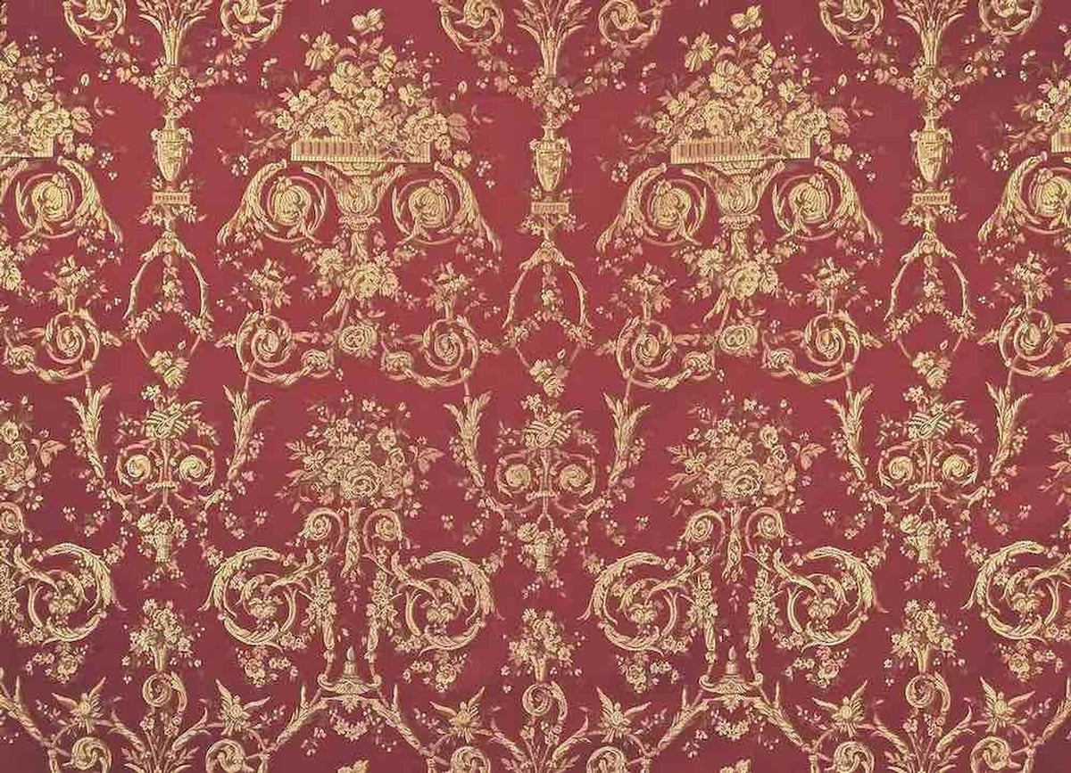 A close-up of the reduced-price VILLA BORGHESE fabric coupon from Arte Fresca Outlet. The image shows the full, opulent pattern of rococo flowers and ornaments in shimmering gold on a rich red background, highlighting the quality of the woven fabric.