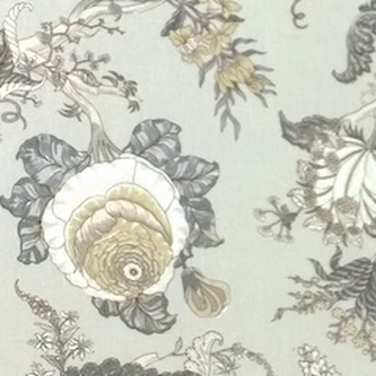 Close-up of Villars Beige/Gray fabric coupon from Arte Fresca Outlet, revealing the intricate details of its botanical print. Muted gray and beige flowers and plants with delicate yellow/olive accents are visible on the light beige-gray background, highlighting the fine lines and smooth texture of this printed 100% cotton fabric piece.

